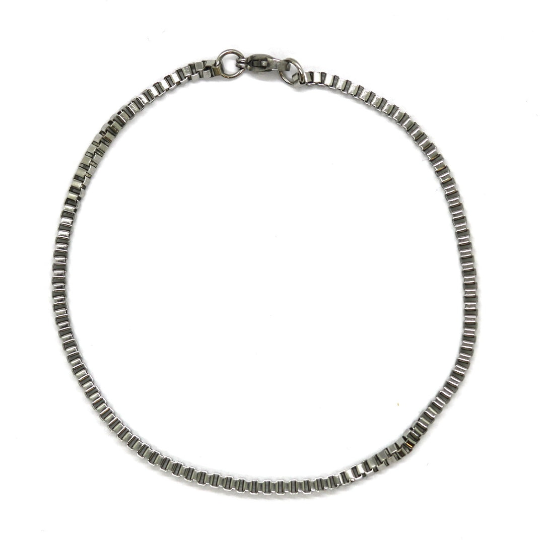 Άντρας με τατουάζ που φορά το Box Silver Bracelet 2mm από ανοξείδωτο ατσάλι σε ασημί χρώμα.