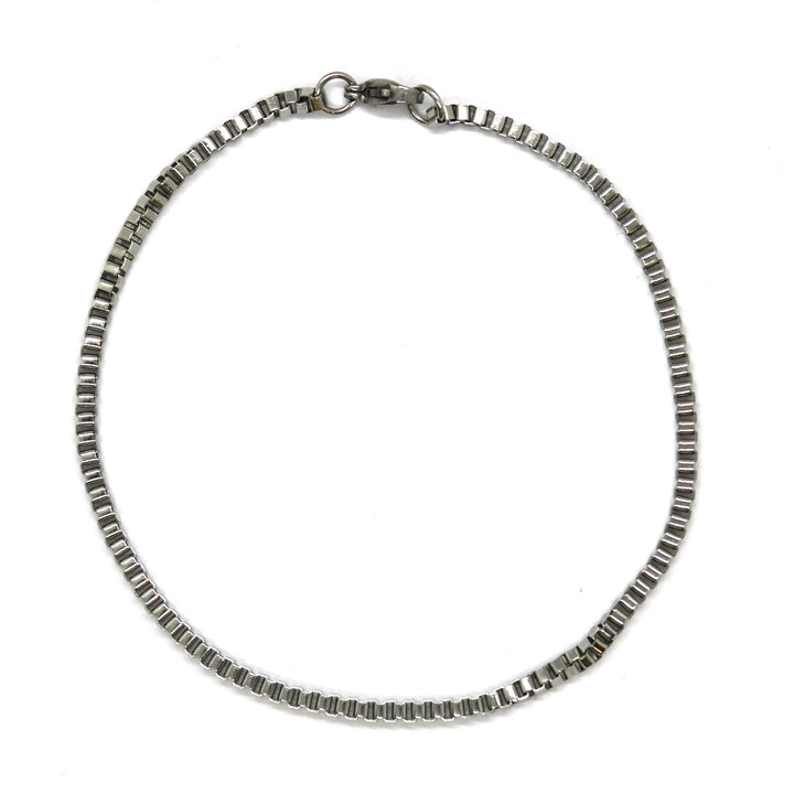 Άντρας με τατουάζ που φορά το Box Silver Bracelet 2mm από ανοξείδωτο ατσάλι σε ασημί χρώμα.